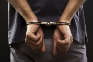 a man in handcuffs representing the article's topic about Understanding California’s Revenge Porn Law