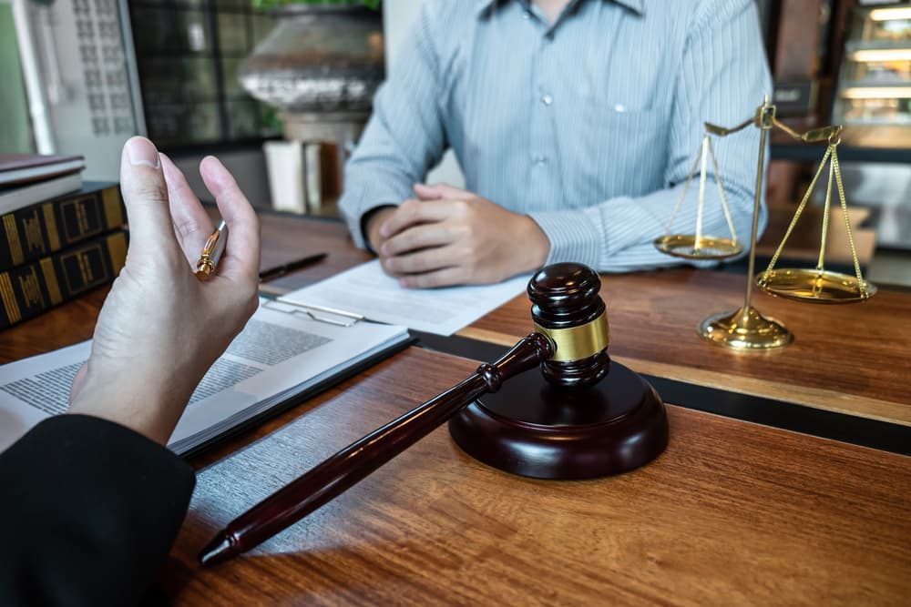 Professional male lawyer or counselor discussing negotiation legal case with client meeting with document contract in office