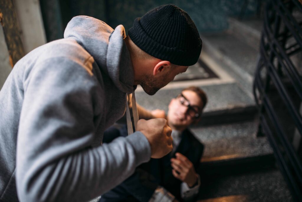 Man threatening another person during an assault in a stairwell, representing violent crime or battery.