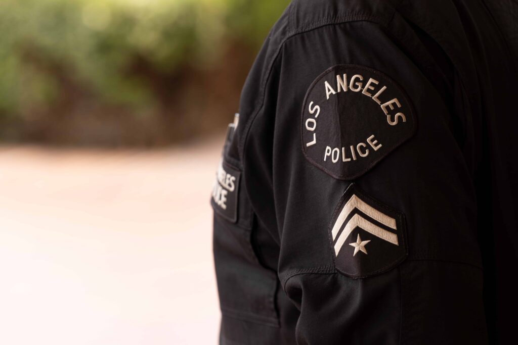 Los Angeles police officer uniform with department and rank patches visible on sleeve.